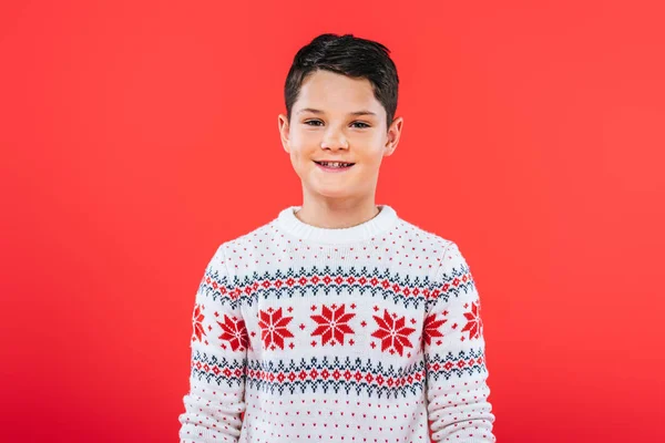 Vista frontale del bambino sorridente in maglione isolato sul rosso — Foto stock