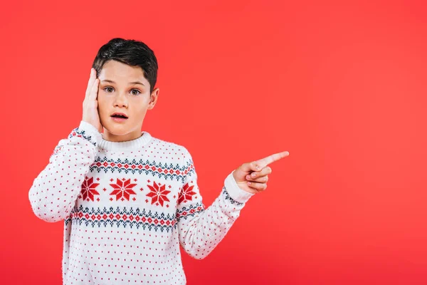 Frontansicht eines überraschten Kindes, das mit dem Finger auf Rot zeigt — Stockfoto