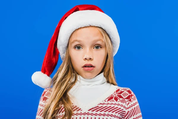 Front view of surprised kid in santa hat isolated on blue — Stock Photo