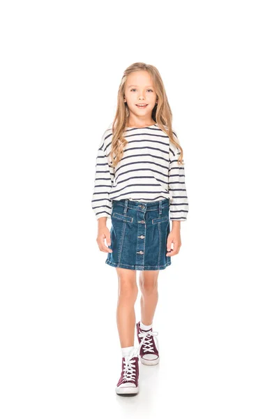 Повнометражний вид усміхненої дитини в джинсовій спідниці, що стоїть на білому — стокове фото
