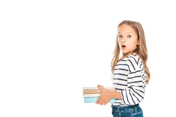 Niño sorprendido sosteniendo libros con la boca abierta aislada en blanco - foto de stock