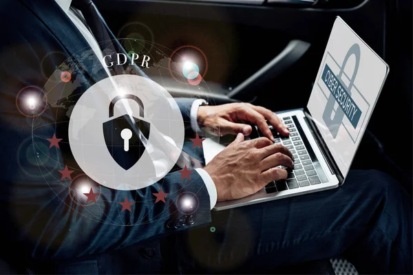 Partial view of african american businessman using laptop in car with gdpr illustration — Stock Photo