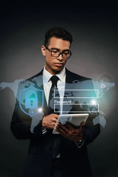 African american businessman in glasses using digital tablet on dark background with cyber security illustration — Stock Photo