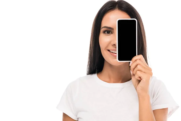 Mujer feliz cubriendo la cara con teléfono inteligente con pantalla en blanco aislado en blanco - foto de stock