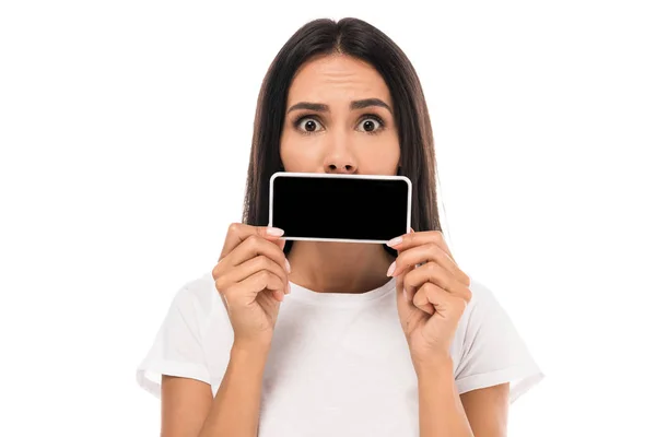 Surprised woman covering mouth with smartphone isolated on white — Stock Photo