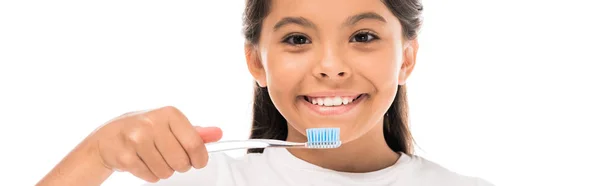 Панорамний знімок щасливої дитини, що тримає зубну щітку ізольовано на білому — стокове фото