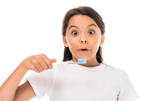 Enfant surpris regardant la caméra et tenant la brosse à dents isolée sur blanc — Photo de stock