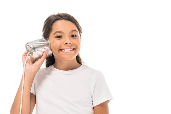 Cheerful kid holding tin can near ear isolated on white — Stock Photo