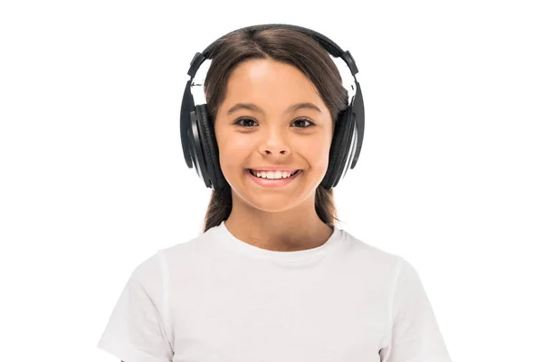 Niño feliz escuchando música en auriculares aislados en blanco - foto de stock