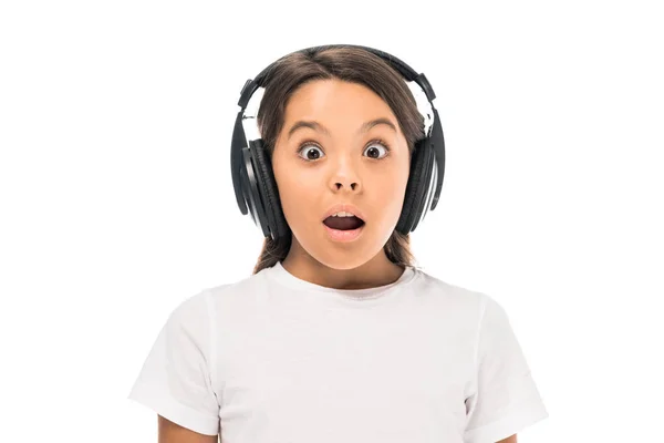 Shocked kid listening music in headphones isolated on white — Stock Photo