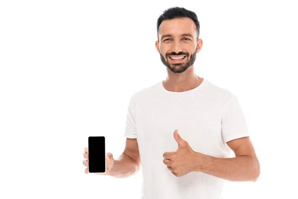 Hombre alegre mostrando el pulgar hacia arriba y sosteniendo el teléfono inteligente con pantalla en blanco aislado en blanco - foto de stock