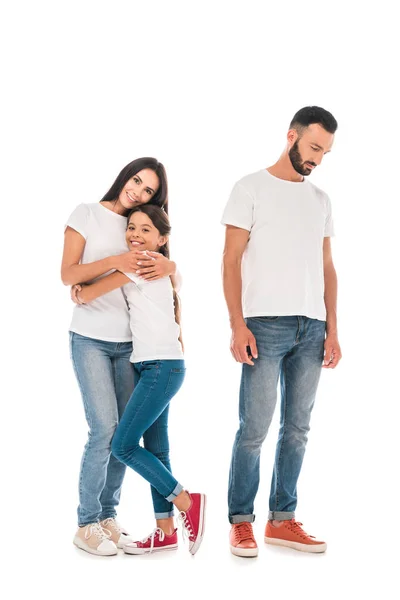 Feliz madre e hija abrazando cerca frustrado hombre aislado en blanco — Stock Photo