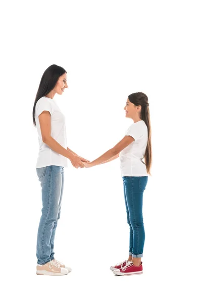 Vista laterale di madre e figlia felice che si tengono le mani isolate su bianco — Foto stock