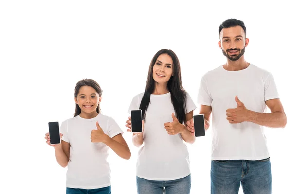 Happy parents and kid showing thumbs up and holding smartphones with blank screens isolated on white — Stock Photo