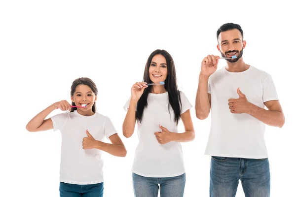 Happy kid near parents brushing teeth and showing thumbs up isolated on white — Stock Photo