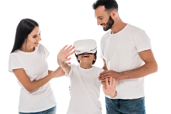 Pais felizes perto da criança no fone de ouvido realidade virtual isolado no branco — Fotografia de Stock