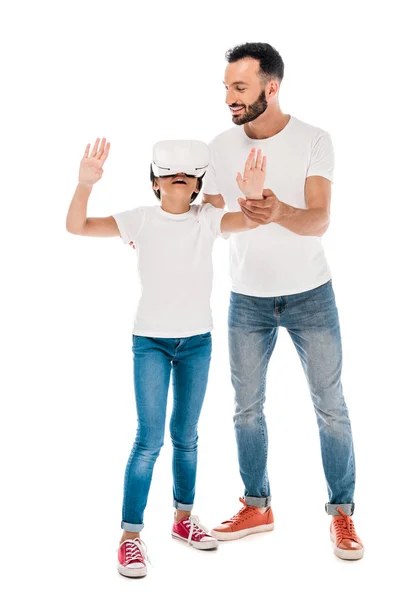 Alegre padre de pie con niño feliz en realidad virtual auriculares aislados en blanco - foto de stock