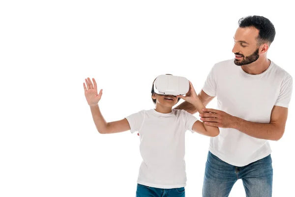 Sonriente padre de pie con niño feliz en realidad virtual auriculares aislados en blanco - foto de stock