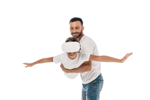 Happy father holding in arms cute kid in virtual reality headset isolated on white — Stock Photo