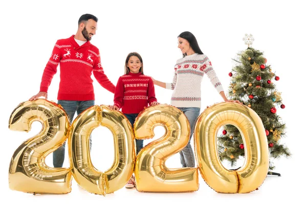 Happy family in sweaters standing near balloons and christmas tree isolated on white — Stock Photo