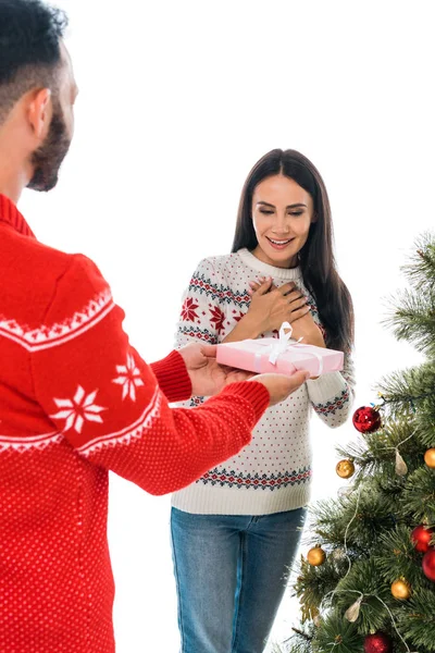 Vista recortada del hombre dando regalo a la mujer alegre y árbol de Navidad aislado en blanco - foto de stock