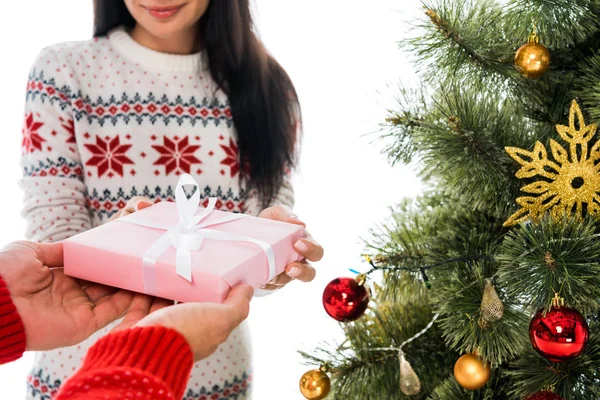 Cropped view of man giving present to woman and christmas tree isolated on white — Stock Photo