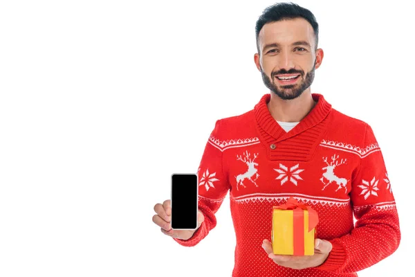 Hombre feliz en suéter apuntando con el dedo al teléfono inteligente aislado en blanco - foto de stock