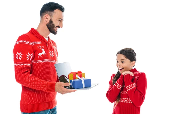 Schöner Mann hält Laptop mit Geschenken in der Nähe aufgeregten Tochter isoliert auf weiß — Stockfoto