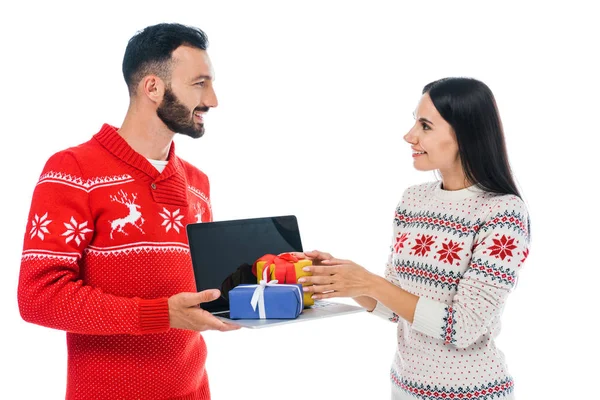 Homme heureux tenant ordinateur portable avec des cadeaux près femme gaie isolé sur blanc — Photo de stock
