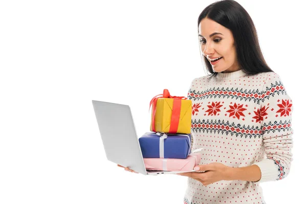 Happy woman in sweater holding laptop with presents isolated on white — Stock Photo