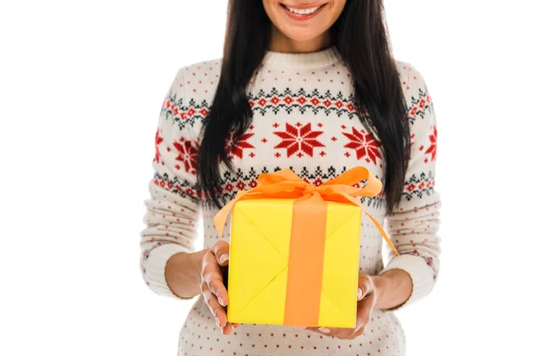 Vista recortada de la mujer alegre en suéter que sostiene la caja de regalo aislada en blanco - foto de stock