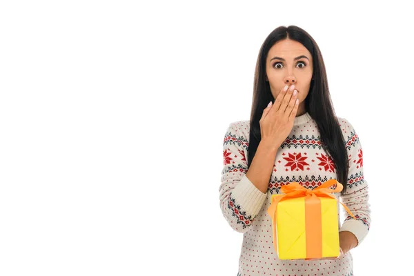 Mujer conmocionada en suéter que cubre la cara y la celebración de caja de regalo aislado en blanco - foto de stock