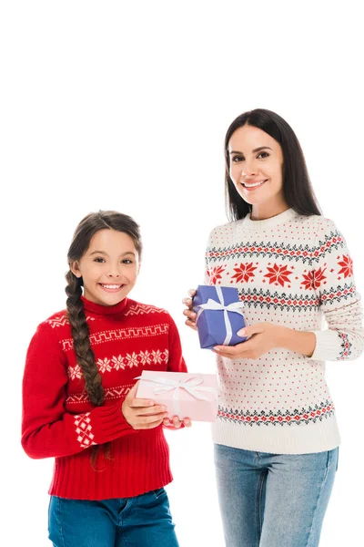 Alegre madre e hija en suéteres sosteniendo regalos aislados en blanco - foto de stock