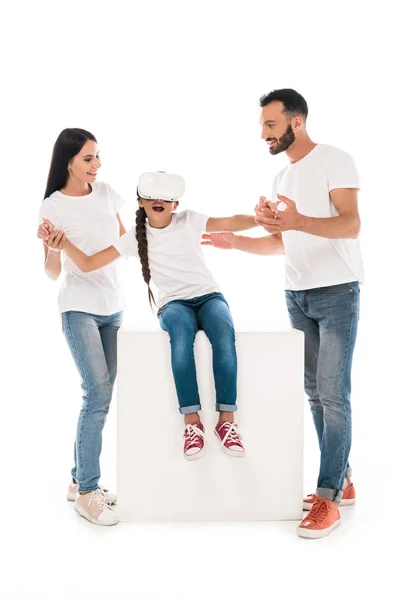 Happy parents holding hands of daughter in virtual reality headset isolated on white — Stock Photo