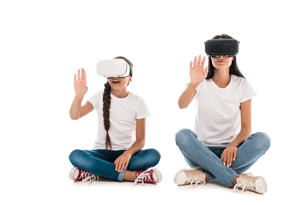 Mother and daughter using virtual reality headsets and gesturing isolated on white — Stock Photo