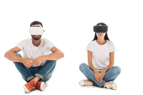 Hombre feliz sentado cerca de la mujer mientras que el uso de auriculares de realidad virtual en blanco - foto de stock