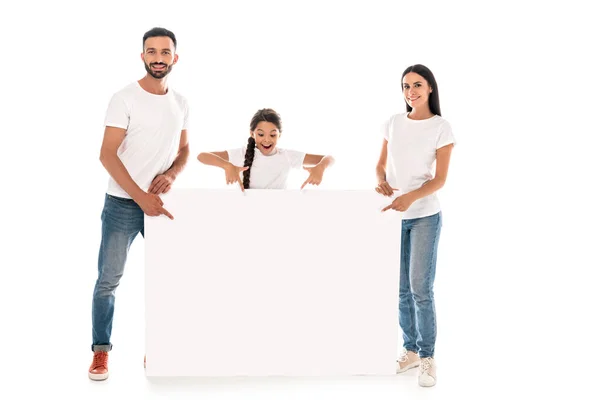 Pais felizes e criança apontando com os dedos para o placard em branco isolado no branco — Fotografia de Stock
