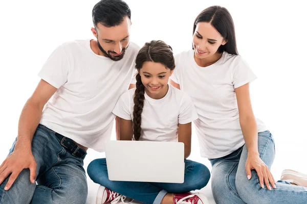 Glückliche Eltern in weißen T-Shirts und ein Kind, das isoliert auf einem weißen Laptop sitzt — Stockfoto