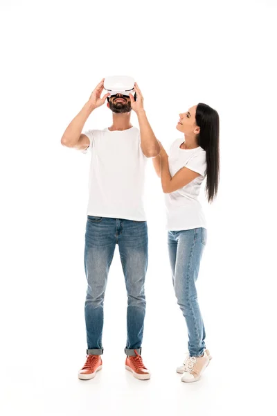 Donna allegra guardando l'uomo barbuto utilizzando cuffie realtà virtuale isolato su bianco — Foto stock
