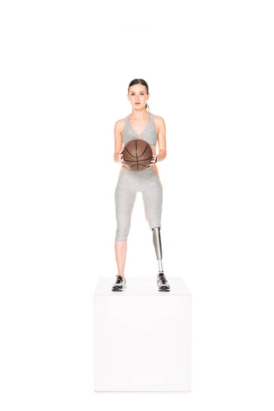 Volle Länge Ansicht der behinderten Sportlerin mit Beinprothese hält Basketballball isoliert auf weiß — Stockfoto