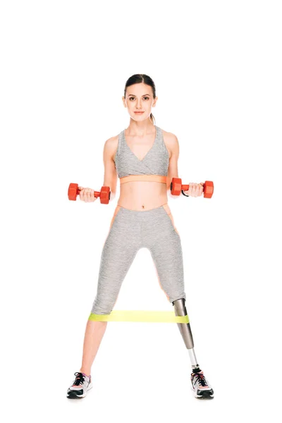 Full length view of disabled sportswoman with resistance band and dumbbells isolated on white — Stock Photo