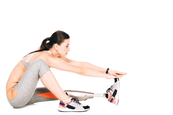 Side view of disabled sportswoman with prosthesis stretching isolated on white — Stock Photo