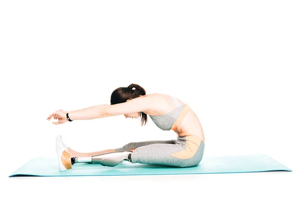 Side view of disabled sportswoman with prosthesis stretching isolated on white — Stock Photo