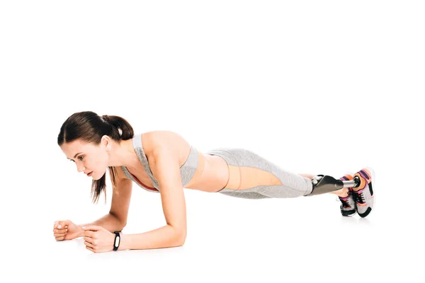 Disabled sportswoman with prosthesis standing in plank isolated on white — Stock Photo