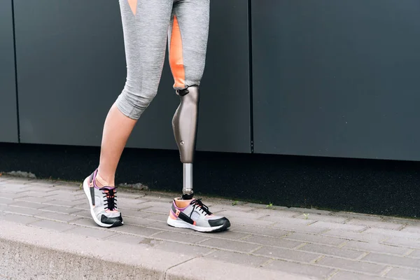 Cropped view of disabled sportswoman with prosthesis on street — Stock Photo