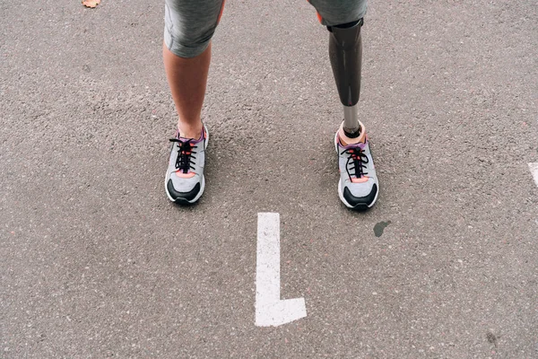 Partial view of disabled sportswoman with prosthesis on street — Stock Photo