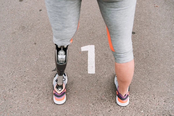 Vista parcial de la deportista discapacitada con prótesis en la calle - foto de stock