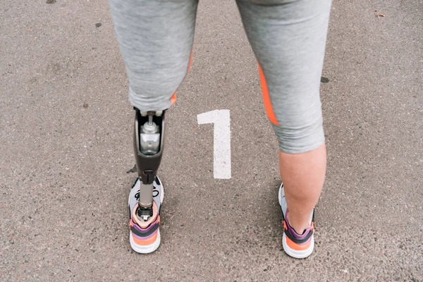 Partial view of disabled sportswoman with prosthesis on street — Stock Photo