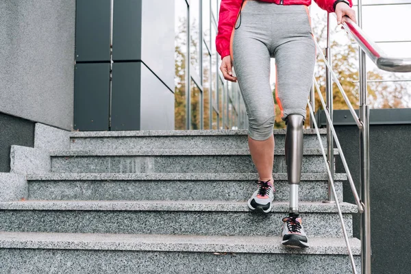 Ausgeschnittener Blick auf behinderte Sportlerin mit Prothese auf Treppe — Stockfoto