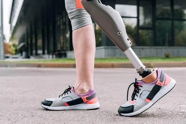 Partial view of disabled sportswoman with prosthesis on street — Stock Photo